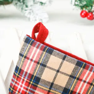 Detailopname van een feestelijke geruite kerstsok met een rode vilten ophanglus