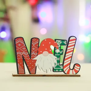 Close-up detail of a festive wooden 'NOEL' ornament featuring a cute Christmas gnome