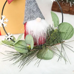 Close-up detail of Christmas gnome wreath with pine needles and eucalyptus leaves decor.