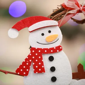 Detailed close-up view of a cute felt snowman ornament on a grapevine Christmas wreath