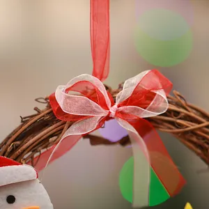 Close-up of a festive Christmas vine wreath with a red and white mesh ribbon bow