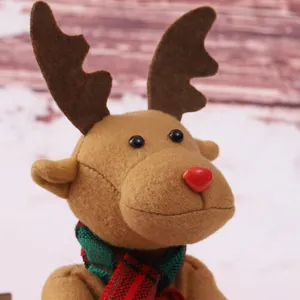 Vista detallada de un reno de Navidad de peluche con nariz roja y bufanda de cuadros