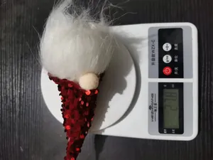Détail montrant la mesure du poids d'un gnome de Noël à paillettes à 27,8 grammes