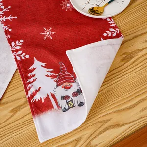 Detail of a red Christmas table runner with a cartoon gnome and snowflake print.