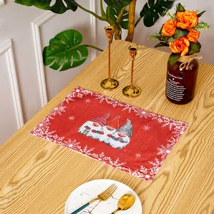 Roter Weihnachts-Tischset mit Wichteln und Schneeflocken auf einem Holztisch