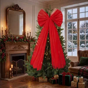 Large red organza bow topper with long streamers on a lit Christmas tree