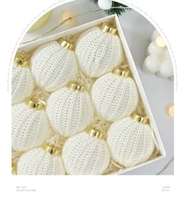 Close-up of white knitted Christmas ornament balls inside an elegant white gift box