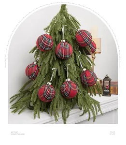 Detailed view of red plaid Christmas ornaments hanging on a decorative evergreen tree.