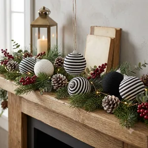 Close-up view of black and white striped knitted Christmas ornaments on a festive wooden mantel