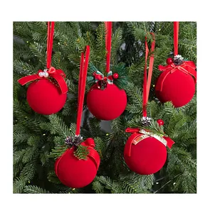 Vista detallada de bolas de Navidad rojas flocadas colgadas en un árbol verde