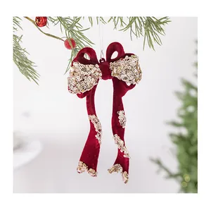 Detailopname van een rode gevlokte kerststrik met gouden lovertjes voor in de kerstboom
