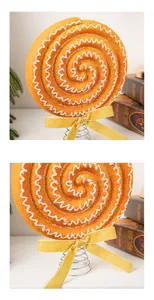 Close-up of orange spiral Christmas lollipop decoration with yellow velvet bow detail