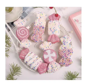 Nahaufnahme von rosa-weißen Schaumstoff-Weihnachtsbonbons mit bunten Streuseln