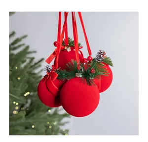 Primer plano de elegantes bolas de Navidad flocadas rojas con detalles de agujas de pino y piña