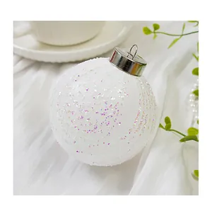 Gros plan d'une boule de Noël blanche avec des paillettes et un filet de mesh délicat