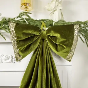 Vista dettagliata di un fiocco natalizio in velluto verde oliva con bordi di paillettes d'oro.