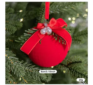 Detalle de bola de Navidad flocada roja de 8 cm con lazo de cinta y adornos de perlas.