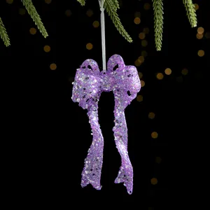 Violetter Glitzer-Weihnachtsbogenschmuck an einem Ast mit festlichen Bokeh-Lichtern