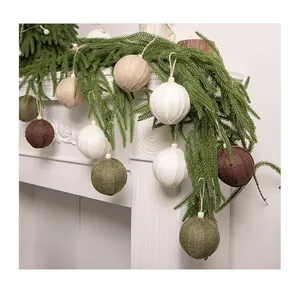 Christmas burlap ball ornaments hanging on festive green pine garland decoration