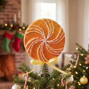 Large orange swirl lollipop Christmas tree topper featuring a yellow bow and glitter sprinkles