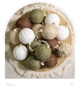 Detailed macro view of earth-toned burlap Christmas ball ornaments on a woven mat