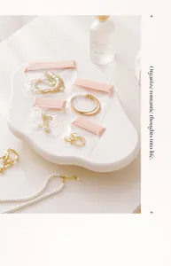 Elegantes bolsas pequeñas rosas con cierre para joyas y pendientes en una bandeja