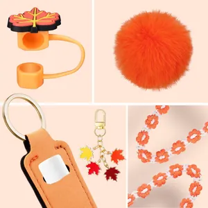 Primo piano del copri cannuccia a foglia arancione e accessori floreali intrecciati