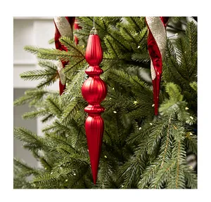 Primer plano de un gran adorno navideño rojo acanalado colgado en un árbol de Navidad