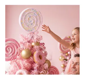Detail shot of pink foam lollipop and donut ornaments on a festive Christmas tree.