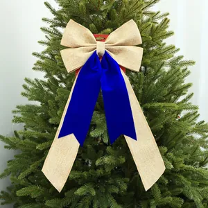 Grande fiocco natalizio decorativo in velluto blu e juta su un albero.