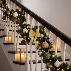 Elegant burlap Christmas ball ornaments decorated on a festive staircase garland.