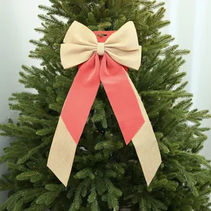 Dettaglio di un grande fiocco natalizio in juta e velluto su un albero di Natale verde