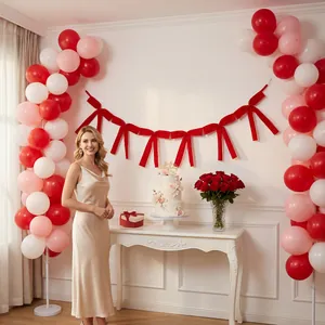 Elegant red velvet bow garland displayed as a stylish birthday party backdrop decoration.