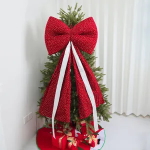 Large red Christmas bow with long decorative streamers on a festive tree topper