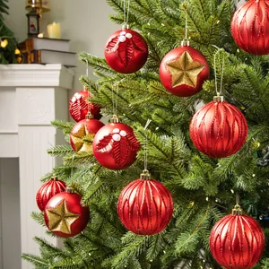 Red Christmas ball ornaments set with glitter stars and leaf patterns on a tree