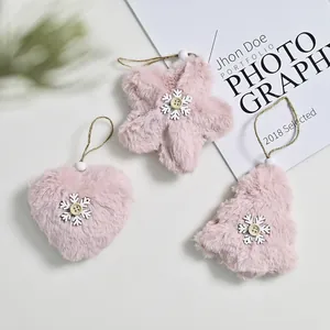 Detail view of pink plush Christmas ornaments with snowflake buttons and twine loops