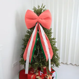 Detailed view of large red Christmas tree topper bow with decorative long streamers