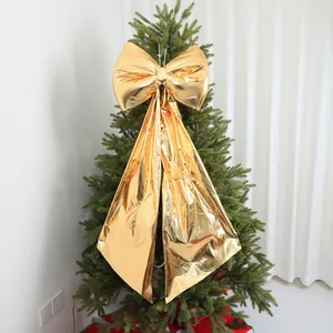 Grande fiocco dorato di Natale appeso a un ramo di un albero di pino molto festivo.