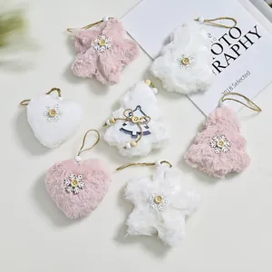 Detailed view of pink and white plush Christmas ornaments in heart, star, and tree shapes