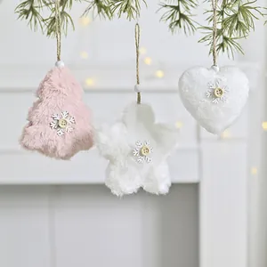 Close-up of fuzzy star, heart, and tree Christmas ornaments hanging from pine branches