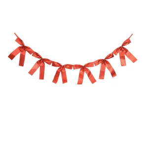 Detailed macro view of a red satin ribbon bow garland for festive party decoration