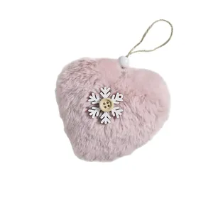 Decorative pink plush heart Christmas ornament featuring a white snowflake and wooden button