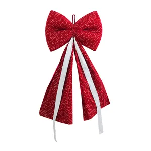 Detail of large red Christmas bow featuring golden heart patterns and white streamers.