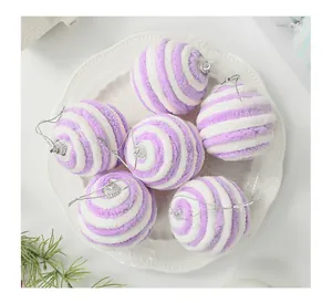 Detailweergave van paars-witte pluizige kerstballen met spiraal op een wit keramisch bord.