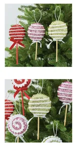 Detailansicht von bunten Glitzer-Lutscher-Anhängern an einem grünen Weihnachtsbaumzweig.