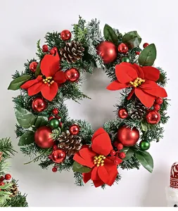 Dettaglio di una corona di Natale con stelle di Natale rosse, palline e pigne decorative