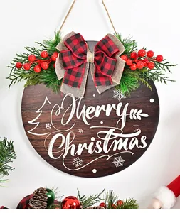 Close-up detail of a rustic Christmas wooden door hanging sign with red berries and a plaid bow.