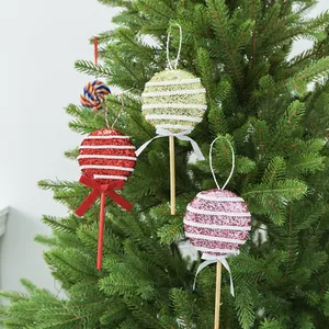 Dekorative glitzernde Schaumstoff-Lutscher-Weihnachtskugeln mit Schleifen am Baum