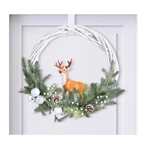 Vista detallada de la corona de Navidad blanca con renos simulados y piñas de pino