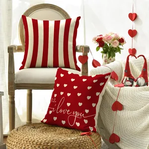Decorative Valentine's Day pillowcases with heart patterns and red stripes on a chair